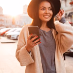 charming-trendy-asian-woman-black-hat-holding-mobile-phone-city-outdoor_171337-13443